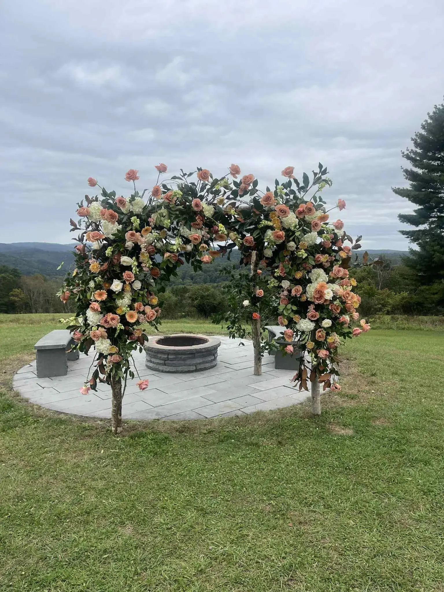 Fleuristry ceremony arch of peach garden roses and hydrangea